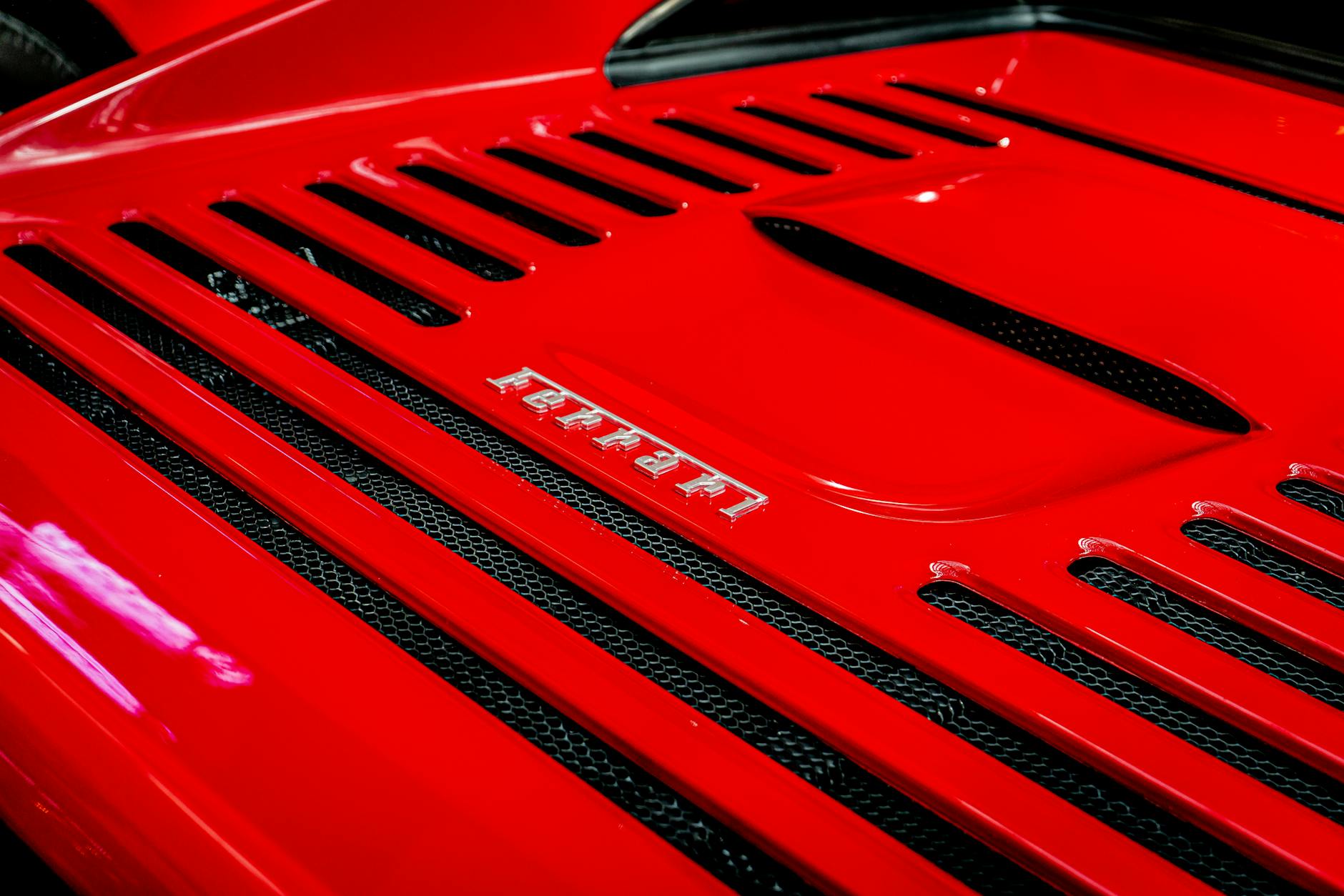 Detailed shot of a Ferrari emblem on a classic red sports car, showcasing luxury and automotive design.